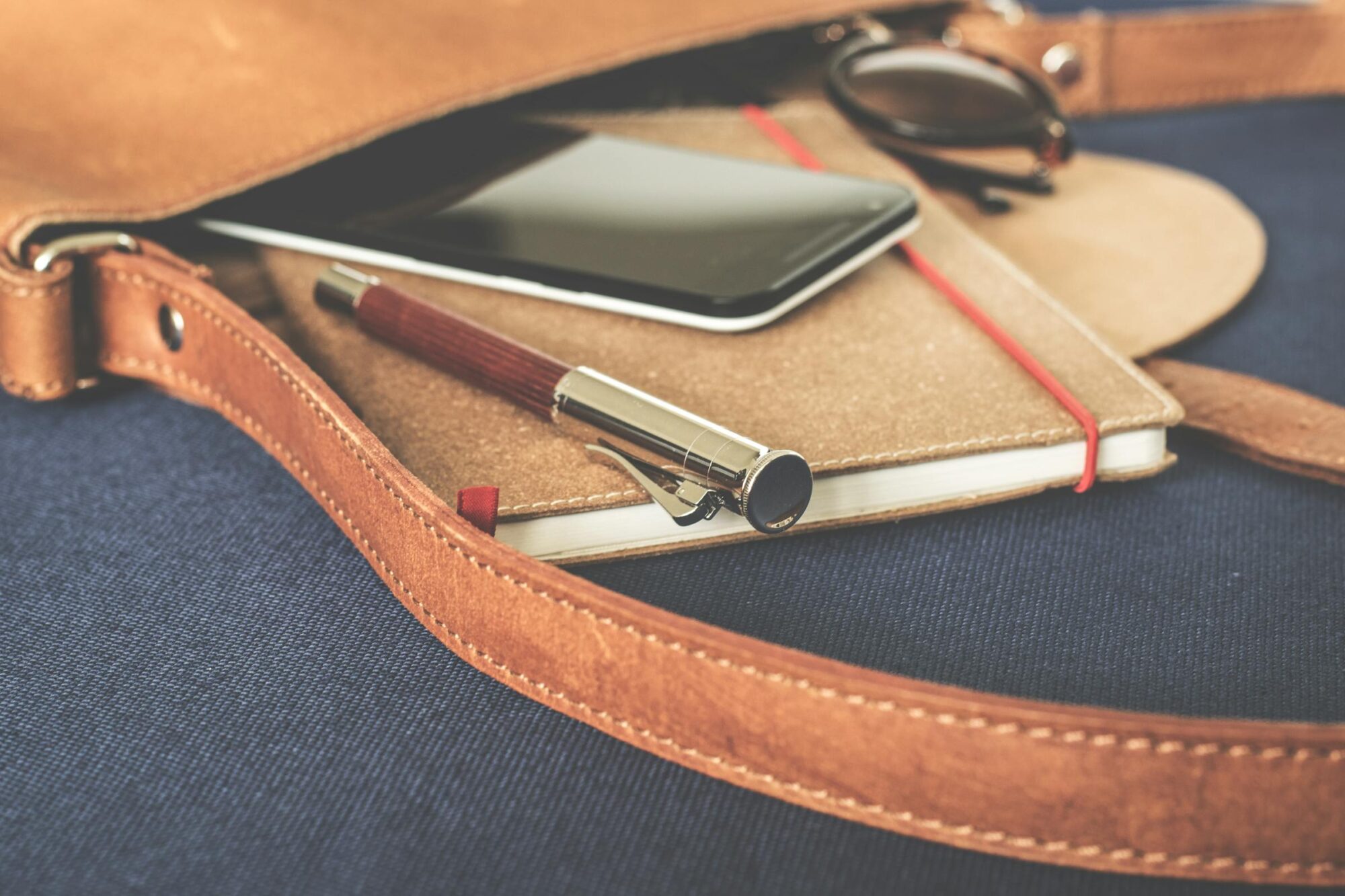 An open leather journal and pen on a dark background.
